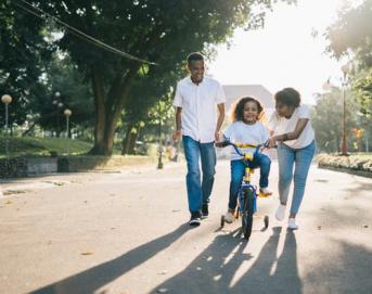 parents and child outdoors, parents teaching daughter to ride a bike